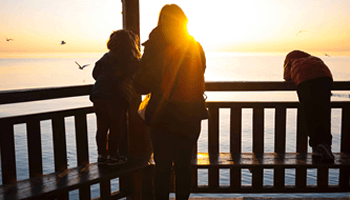 Image | person with children standing on balcony overlooking the ocean